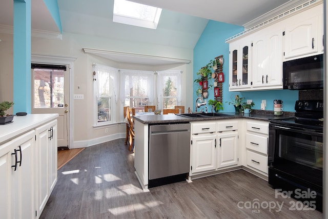 kitchen featuring black appliances, a peninsula, a sink, and white cabinetry