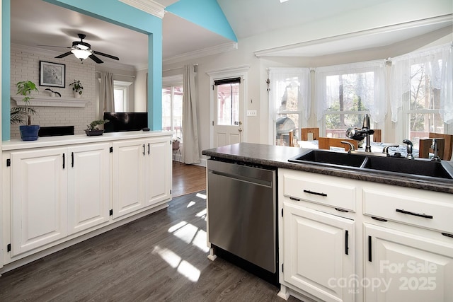 kitchen with dark wood finished floors, stainless steel dishwasher, ornamental molding, white cabinetry, and a sink