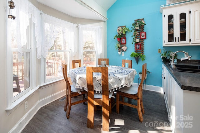 dining space with lofted ceiling, dark wood-style floors, and a wealth of natural light