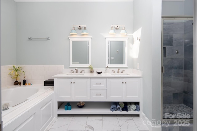 bathroom featuring double vanity, marble finish floor, a shower stall, and a sink