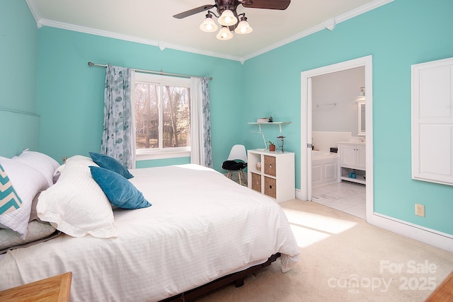 carpeted bedroom featuring ceiling fan, crown molding, baseboards, and ensuite bathroom