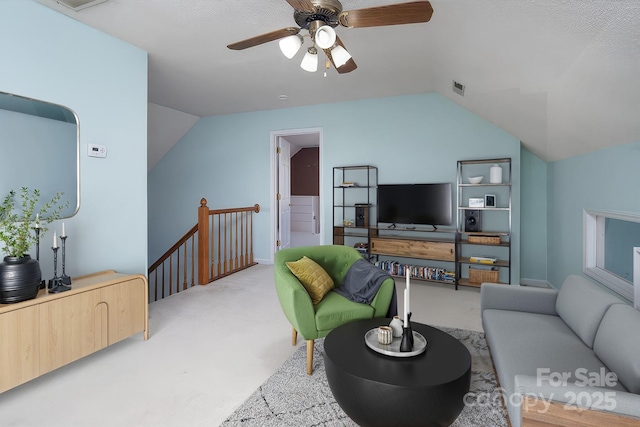 carpeted living room featuring lofted ceiling, visible vents, and a ceiling fan