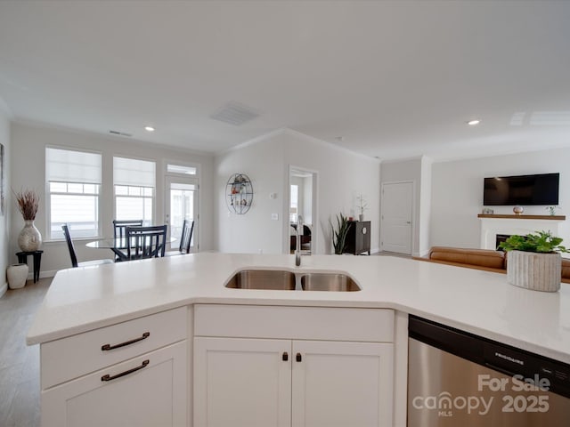 kitchen featuring sink, stainless steel dishwasher, white cabinets, and crown molding