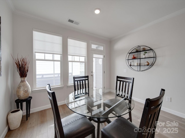 dining area featuring ornamental molding and hardwood / wood-style floors