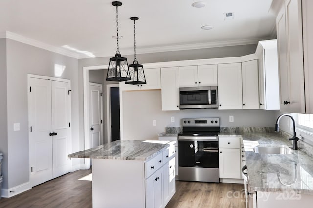 kitchen featuring a kitchen island, sink, stainless steel appliances, and white cabinetry