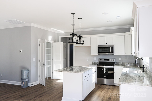 kitchen with appliances with stainless steel finishes, a kitchen island, sink, and white cabinets