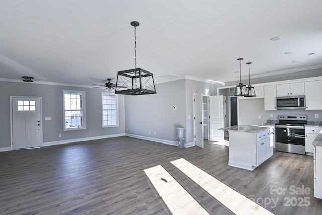 kitchen featuring a center island, white cabinetry, decorative light fixtures, stainless steel appliances, and ornamental molding