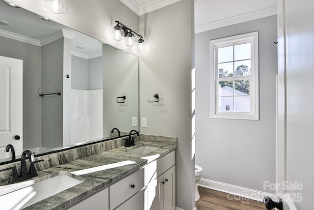 bathroom featuring wood-type flooring, vanity, a shower, toilet, and ornamental molding