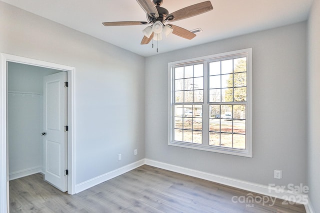 spare room with ceiling fan, light hardwood / wood-style floors, and a healthy amount of sunlight