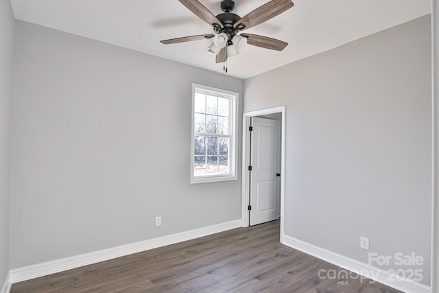 spare room with ceiling fan and dark wood-type flooring