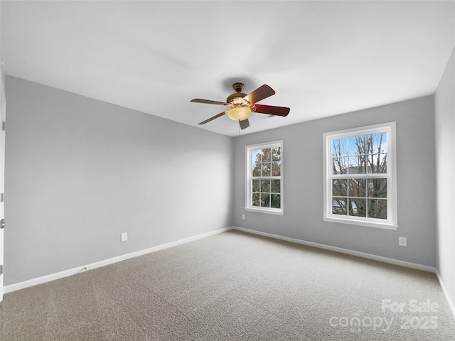 spare room with carpet floors, ceiling fan, and baseboards