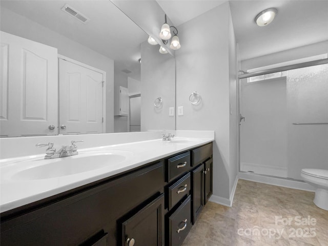 full bath featuring visible vents, a sink, a shower stall, and double vanity