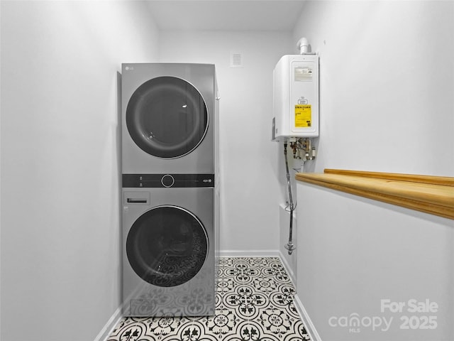 washroom featuring light tile patterned floors, laundry area, stacked washer / dryer, baseboards, and water heater