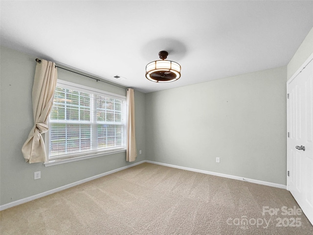 carpeted empty room with visible vents and baseboards