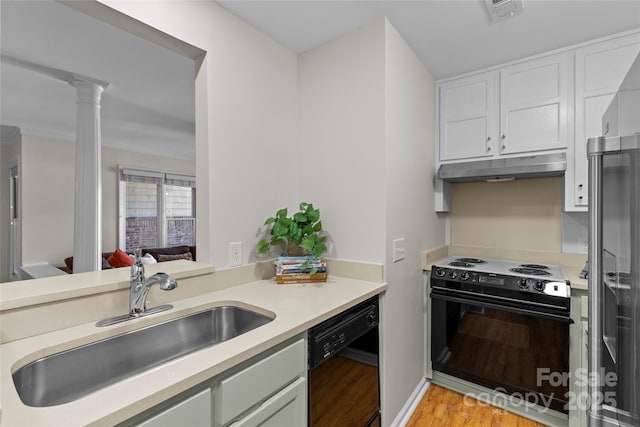 kitchen featuring black dishwasher, electric stove, light countertops, under cabinet range hood, and a sink