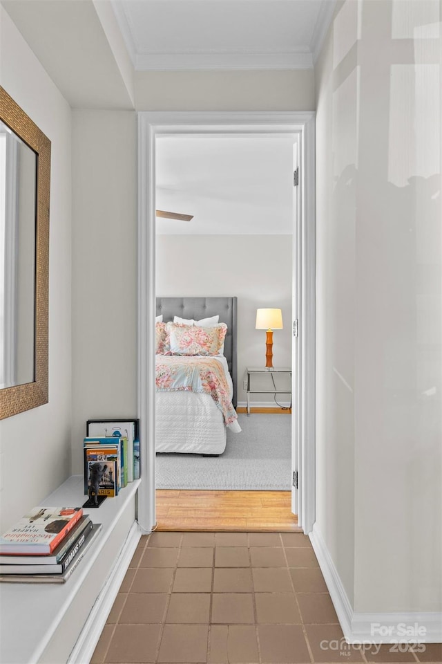 hallway with ornamental molding and dark tile patterned floors