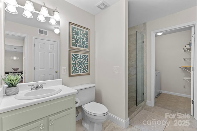 bathroom featuring baseboards, visible vents, tiled shower, and vanity