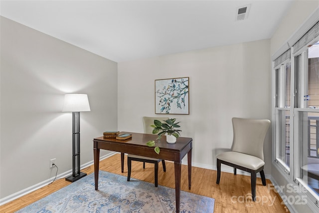 office area featuring baseboards, visible vents, and light wood-style floors