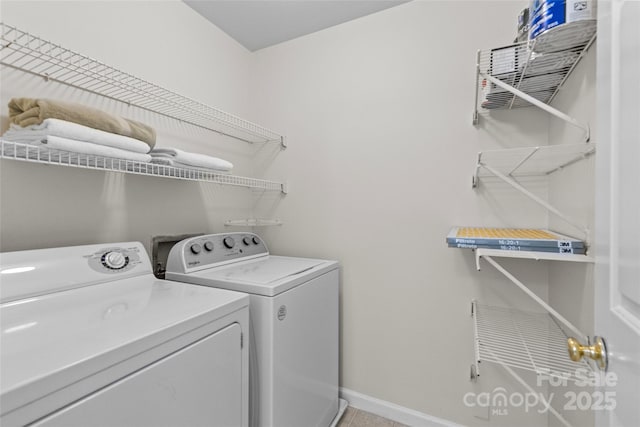 laundry area featuring laundry area, baseboards, and washer and clothes dryer