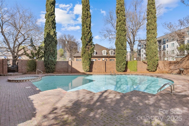 view of pool featuring a fenced in pool, fence, and an in ground hot tub