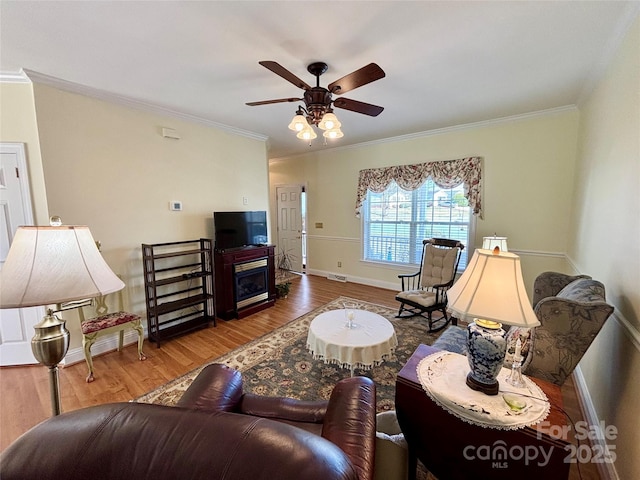 living room featuring hardwood / wood-style flooring, ornamental molding, and ceiling fan