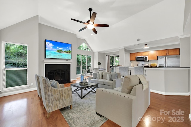 living room featuring ceiling fan, high vaulted ceiling, and light hardwood / wood-style floors