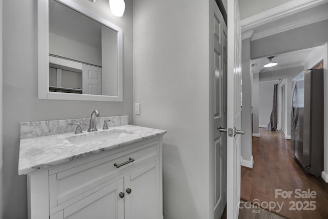 bathroom featuring crown molding, vanity, and hardwood / wood-style flooring