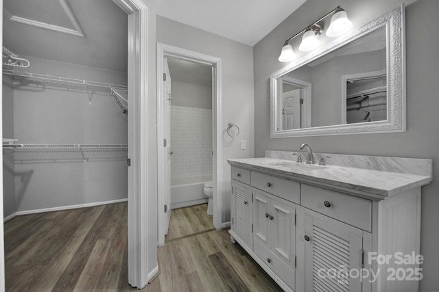 full bathroom featuring vanity, tiled shower / bath combo, wood-type flooring, and toilet