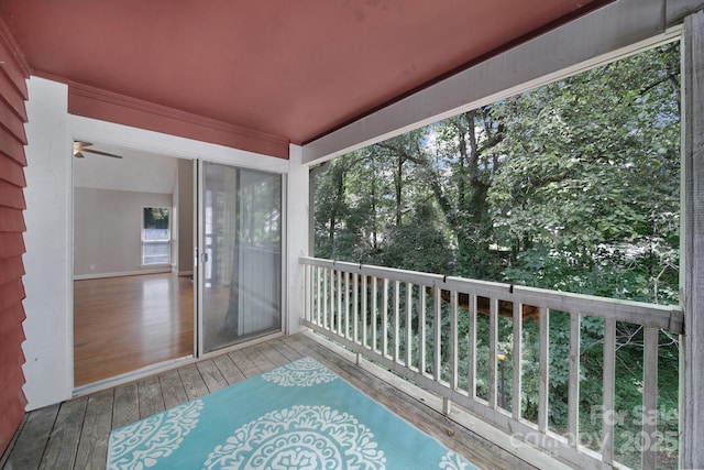 unfurnished sunroom featuring ceiling fan