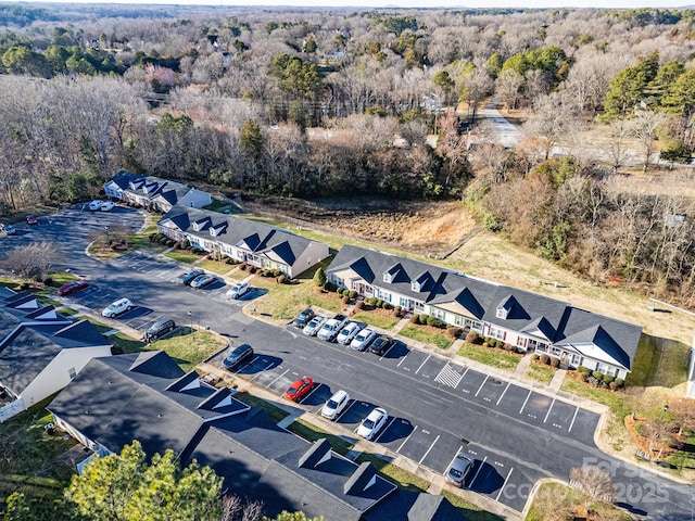 drone / aerial view featuring a forest view and a residential view