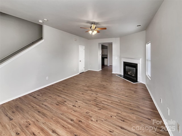 8353 Ainsworth St, Charlotte, NC 28216 - unfurnished living room featuring ceiling fan, a glass covered fireplace, wood finished floors, and baseboards