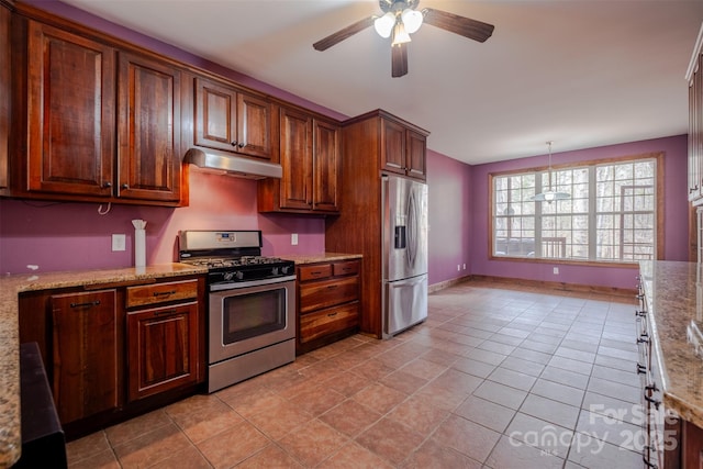 kitchen featuring light stone countertops, under cabinet range hood, light tile patterned floors, and stainless steel appliances