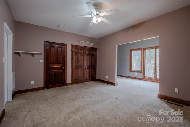 unfurnished bedroom featuring carpet floors, baseboards, and a ceiling fan