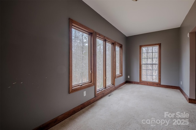 unfurnished room with light carpet, visible vents, and baseboards