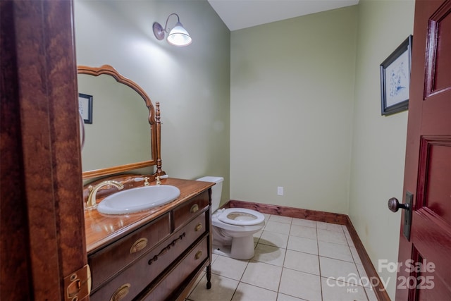 bathroom featuring toilet, baseboards, vanity, and tile patterned floors