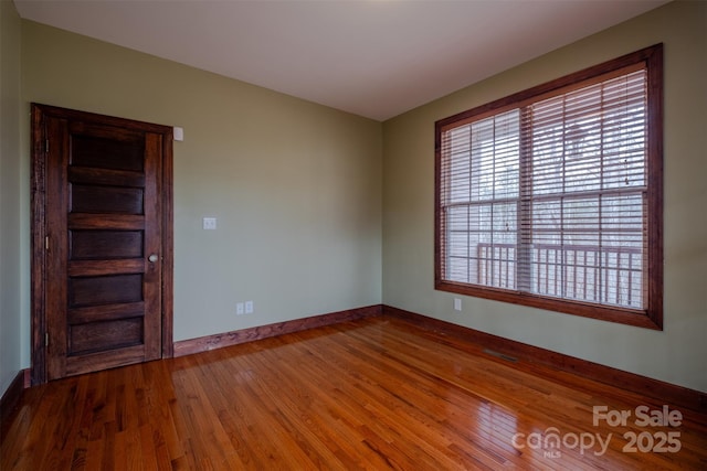 unfurnished room with wood finished floors and baseboards