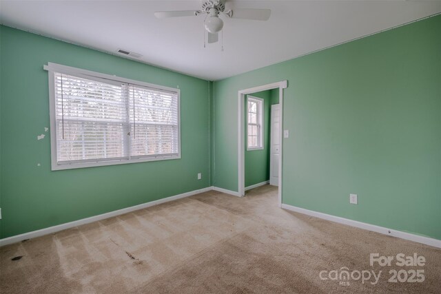 unfurnished room with a ceiling fan, baseboards, visible vents, and carpet flooring