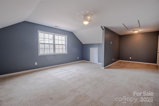 additional living space featuring carpet floors, baseboards, visible vents, and vaulted ceiling