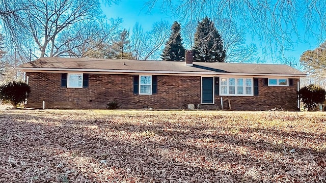 ranch-style home with brick siding and a chimney