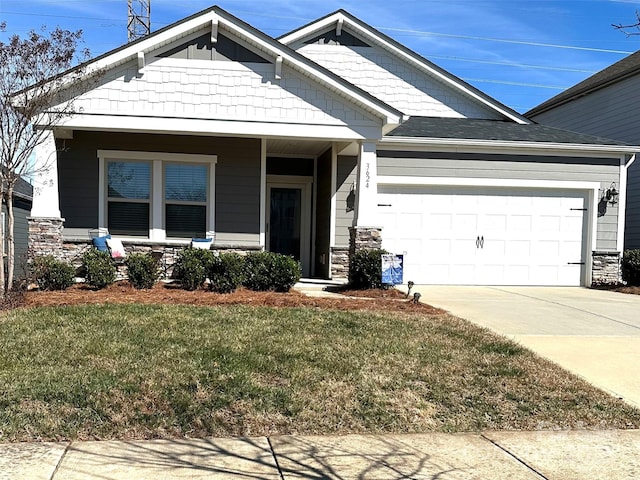 craftsman-style home with a garage, stone siding, concrete driveway, and a front yard