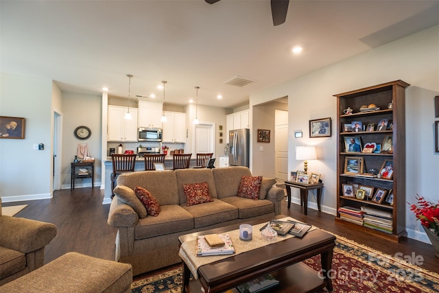 living area featuring baseboards, visible vents, dark wood finished floors, and recessed lighting