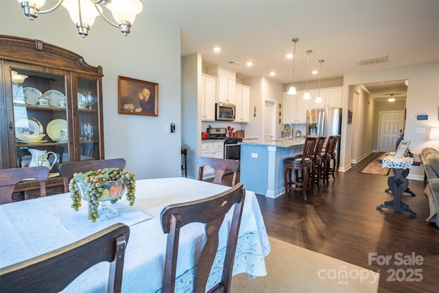 dining space featuring recessed lighting, visible vents, baseboards, dark wood-style floors, and an inviting chandelier