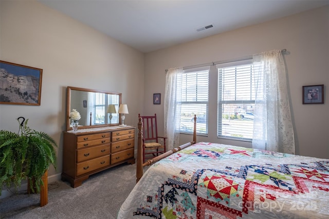 carpeted bedroom featuring visible vents