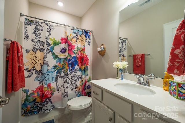 bathroom featuring toilet, shower / bath combination with curtain, vanity, and visible vents