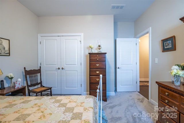 bedroom with light colored carpet, a closet, visible vents, and baseboards