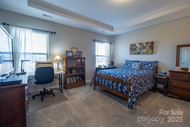 bedroom with visible vents, baseboards, ornamental molding, a tray ceiling, and carpet floors