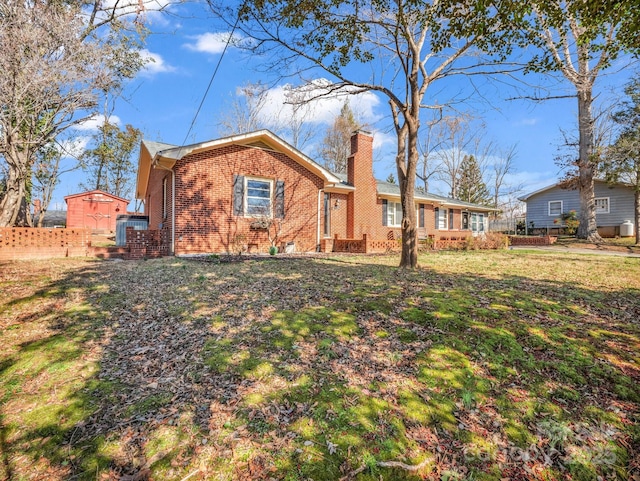 view of front of house with brick siding, a chimney, central air condition unit, a front yard, and fence