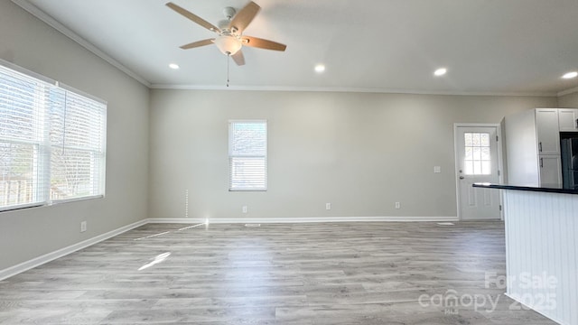 unfurnished room with ceiling fan, ornamental molding, and light wood-type flooring