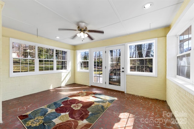 unfurnished sunroom with ceiling fan and a wealth of natural light