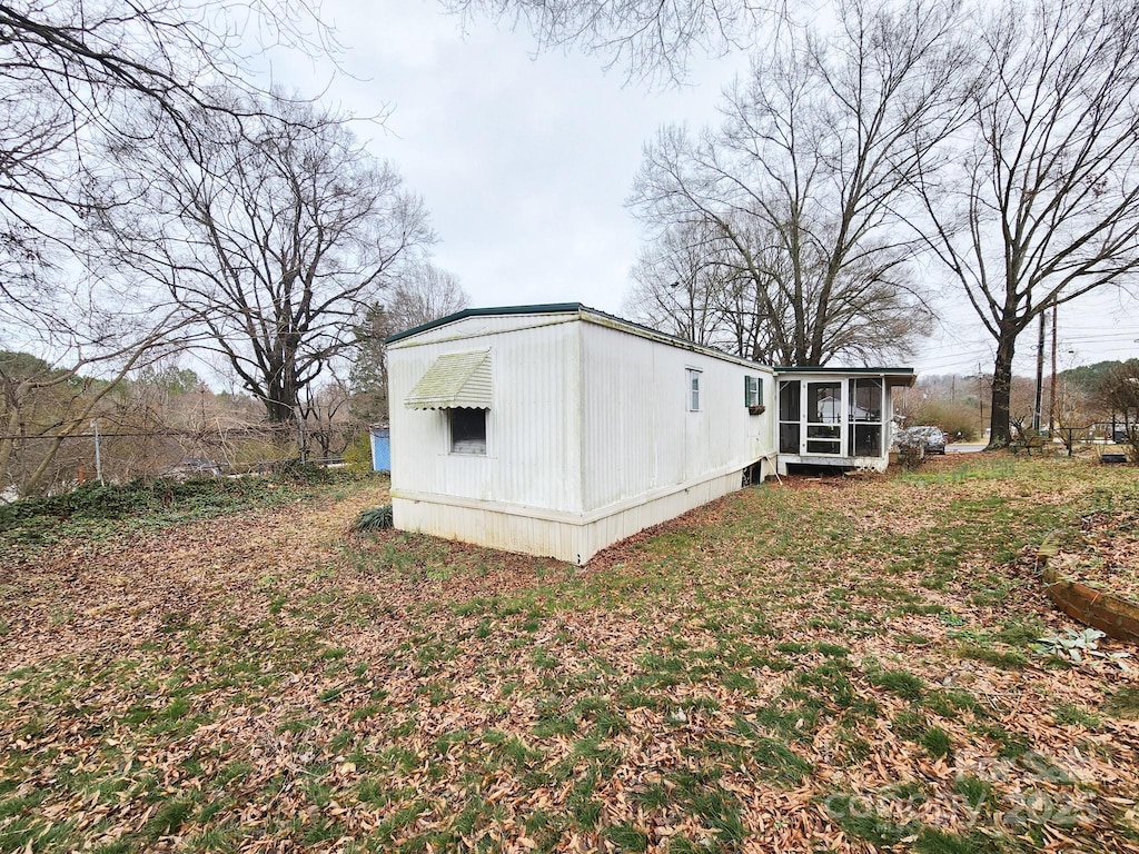 rear view of property featuring a sunroom